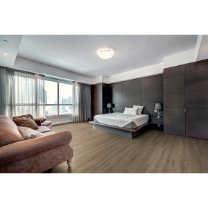 Pavimento laminato chiaro posato in una camera da letto. Ambiente accogliente con divano e letto.