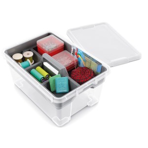 Contenitore trasparente con scomparti per accessori da cucito come fili, aghi e bottoni.