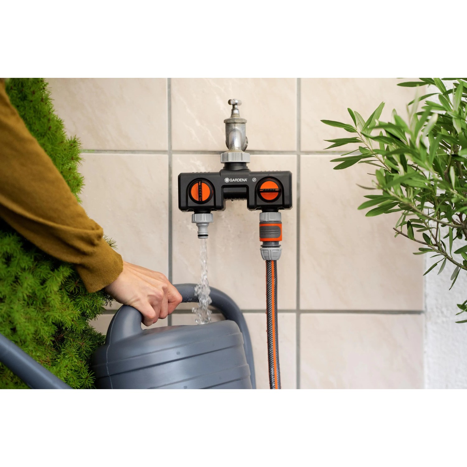 Distributore a 2 vie Gardena su rubinetto con tubo e annaffiatoio.