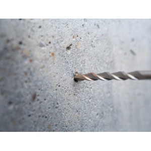 Il trapano a percussione LUX Hammer Classic SDS-Plus fora un foro nel muro di cemento.