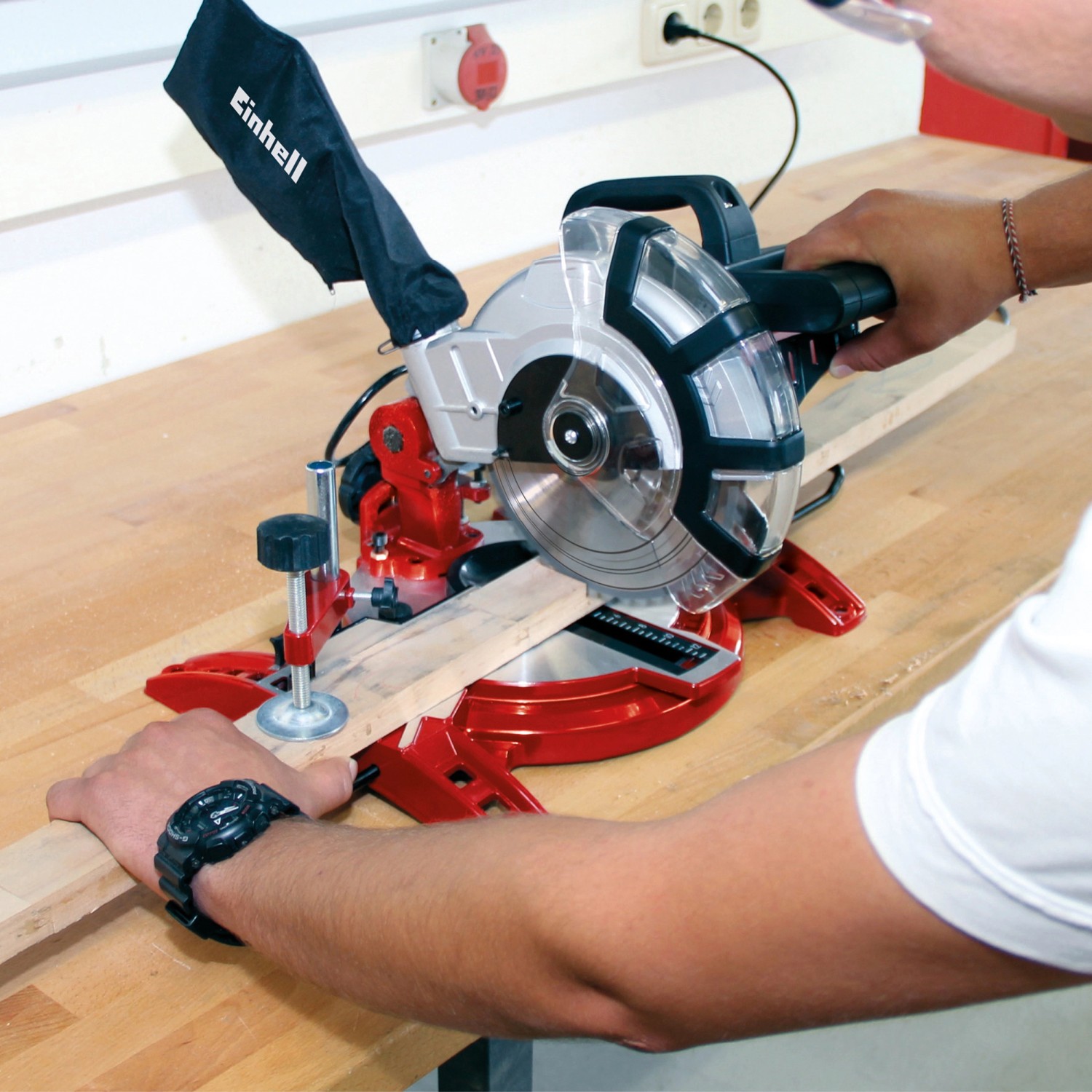 Troncatrice Einhell TC-MS 2112 in uso, taglia legno su un banco da lavoro.