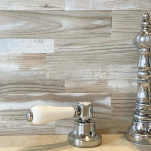 Piastrella a mosaico t.b.t. effetto legno chiaro con rubinetto in bagno.