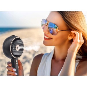 Donna che usa il ventilatore t.b.t. sulla spiaggia per una brezza fresca.