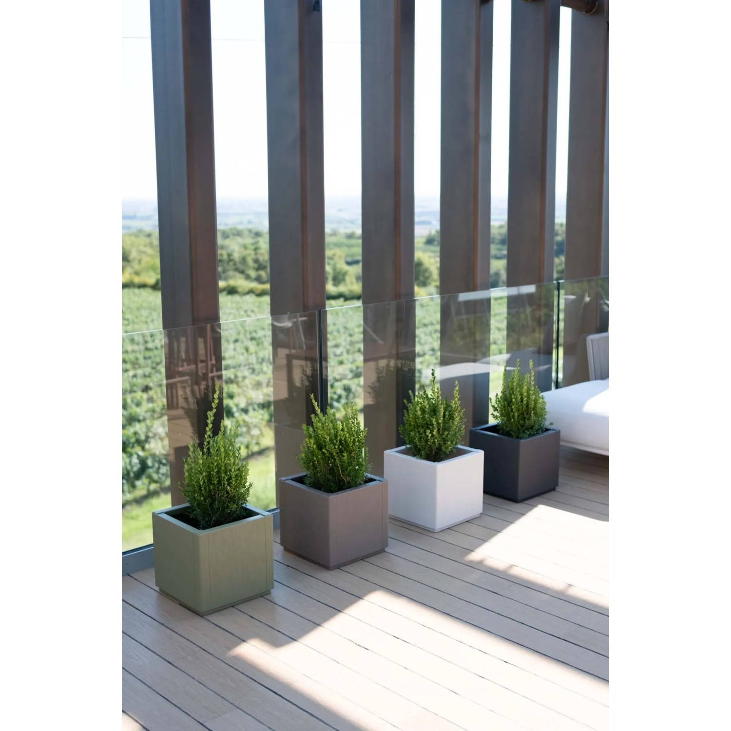 Fioriere da esterno t.b.t. multicolore in plastica con piante su una terrazza.