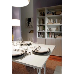 Tavolo da appoggio t.b.t. bianco apparecchiato con piatti e bicchieri in sala da pranzo.