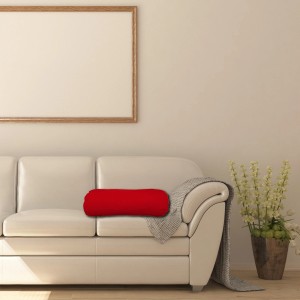 Cuscino cilindrico rosso su un divano. Cuscino decorativo per soggiorno.
