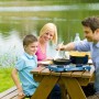 Famiglia in campeggio con fornello da campeggio t.b.t. vicino al lago.