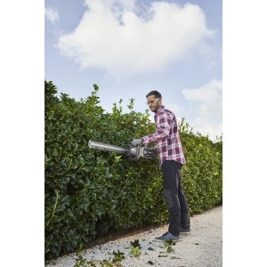 Uomo che taglia la siepe con tagliasiepi a batteria. Giardinaggio con t.b.t.