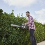 Uomo che taglia la siepe con tagliasiepi a batteria. Giardinaggio con t.b.t.