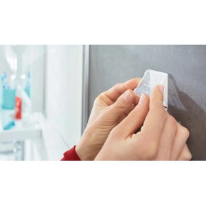 Applicazione di un gancio adesivo trasparente t.b.t. in bagno.