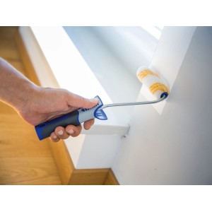 Mano che dipinge una parete bianca con rullo a dispersione LUX (12 cm). Rullo per superfici lisce.