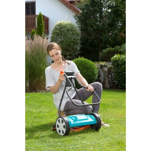 Donna utilizza il tosaerba a cilindro Gardena Classic 330 in giardino. Tosaerba manuale per un taglio preciso.
