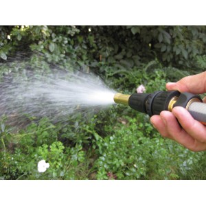 Mano che tiene la lancia per irrigazione t.b.t. mentre annaffia le piante.