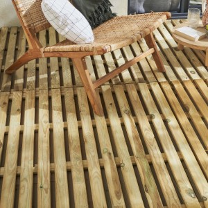 Piastrelle in legno chiaro posate come pavimentazione per patio con sedia.