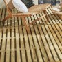 Piastrelle in legno chiaro posate come pavimentazione per patio con sedia.