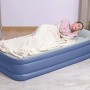Materasso ad aria blu con persona che dorme e coperta. Ideale per il campeggio.