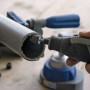 Miniutensile Dremel Lite 7760-15 che leviga un tubo.