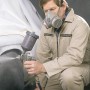Uomo con respiratore e pistola a spruzzo. Cartuccia filtro LUX A1B1E1K1 per protezione respiratoria.