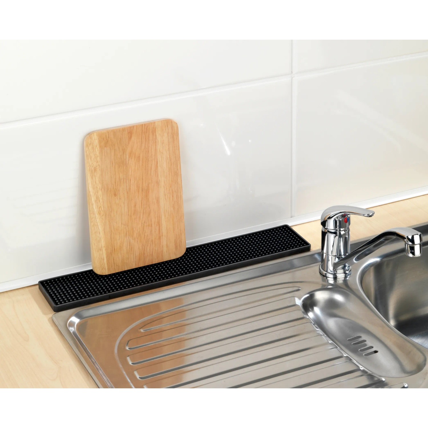 Tappetino scolapiatti Wenko Slim nero (42 cm) accanto al lavello con tagliere in legno per asciugare.