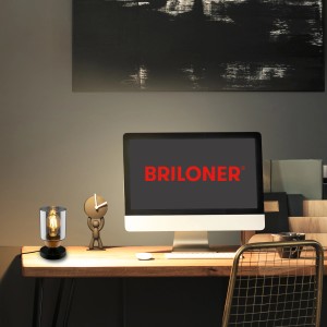 Lampada da scrivania su scrivania con computer. Lampada decorativa in stile industriale.