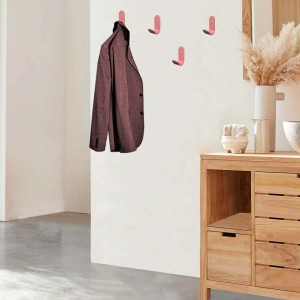 Appendiabiti rosa a muro, uno con giacca. Porta abiti sullo sfondo.