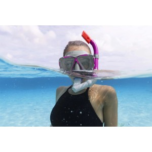 Donna con maschera da sub e boccaglio in mare. Accessori per sport acquatici.