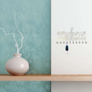 Bacheca bianca t.b.t. con note musicali e portachiavi appeso al muro.