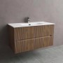 Mobile bagno t.b.t. con finitura legno scanalato e lavabo bianco.