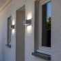 Lampada da parete per esterni a LED LUTEC Gemini bianca su una parete di casa.