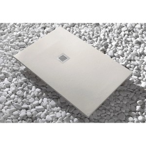 Piatto doccia rettangolare chiaro con scarico quadrato su ciottoli bianchi.