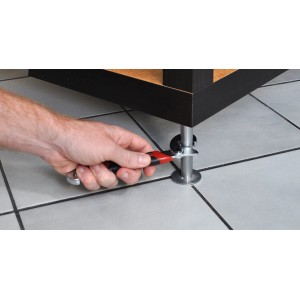 Mano che regola una gamba del mobile con una chiave meccanica (t.b.t.).