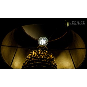 Primo piano di una lampadina LED E27 in un portalampada dorato sotto un paralume.