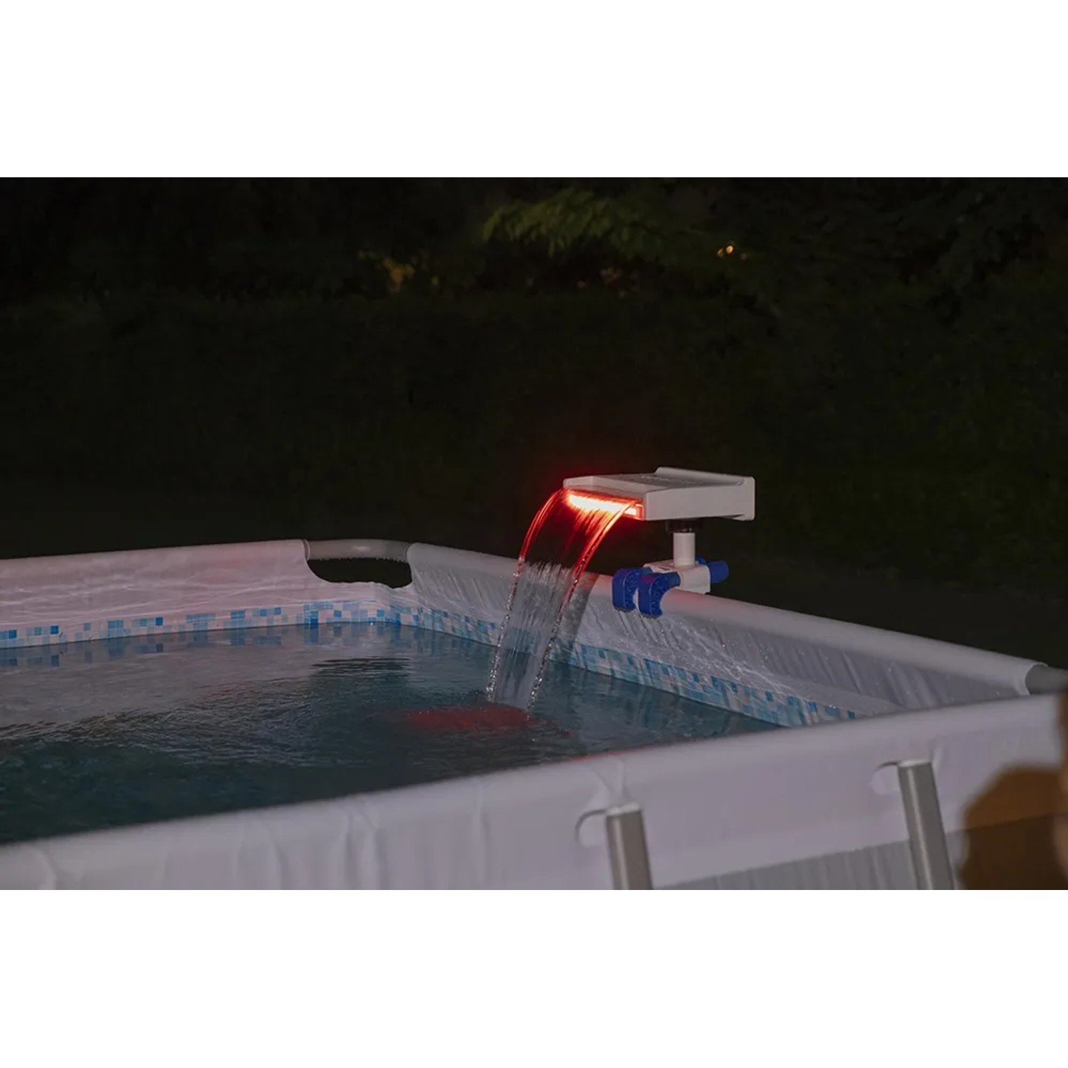 Cascata per piscina Flowclear™ con luce LED sul bordo piscina, illuminata di rosso.