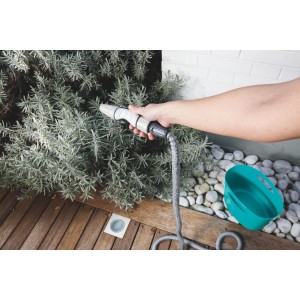 Scena da giardino con tubo per irrigazione t.b.t. e annaffiatoio.