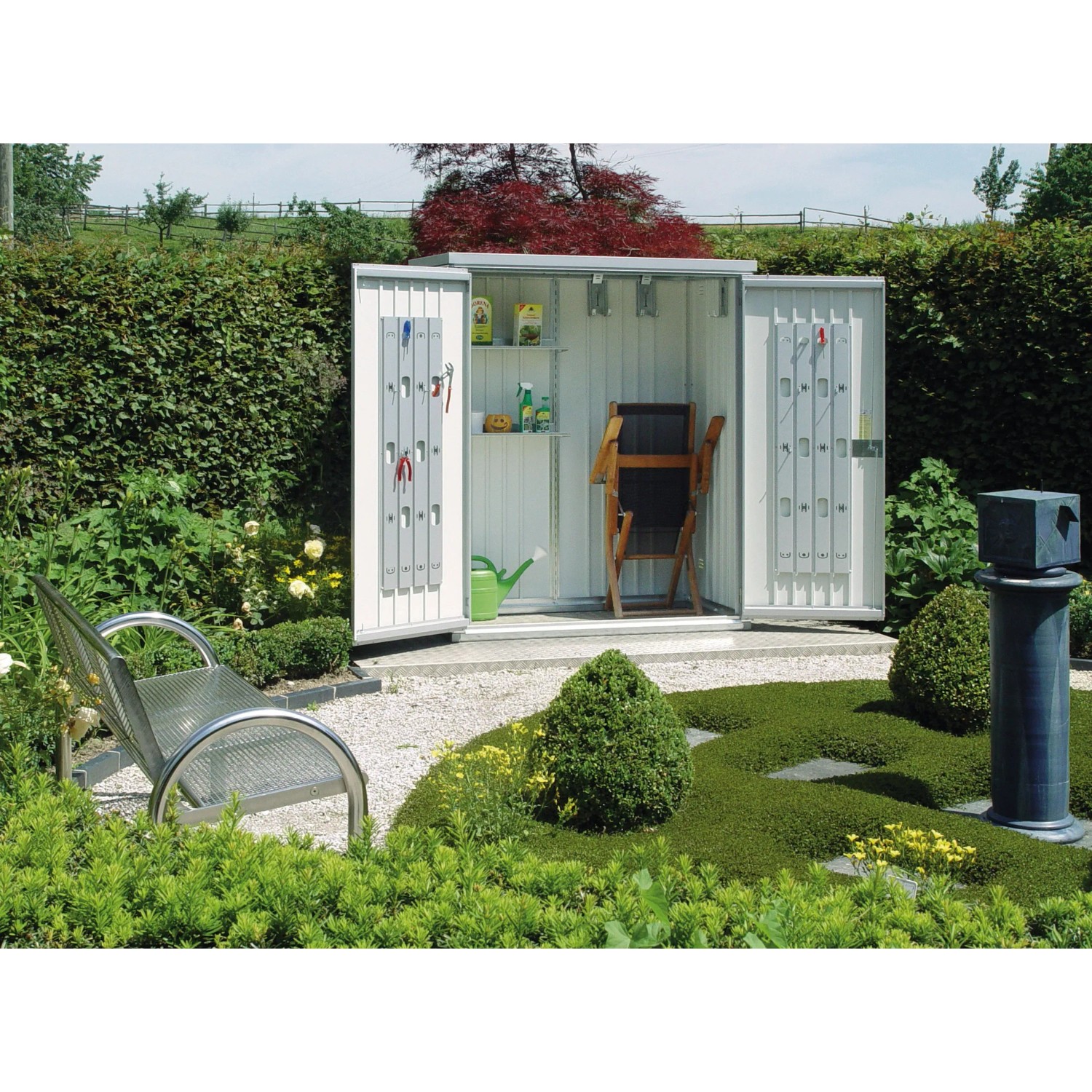Casetta da giardino Biohort Gr. 150, argento metallizzato, con ante aperte e accessori in giardino.