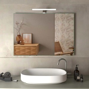 Specchio da parete rettangolare con illuminazione sopra un lavandino in bagno.