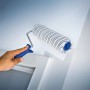 Rullo a dispersione LUX 25cm in azione: rullo per pittura a pelo corto a righe grigie che dipinge una parete.