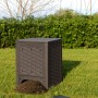Compostiera t.b.t. marrone in giardino con terra di compostaggio davanti.