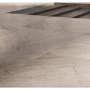 Piastrelle per pavimenti beige effetto marmo con scale sullo sfondo.