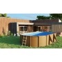 Piscina Gre Mauritius ovale effetto legno in giardino. Grande piscina fuori terra con copertura blu e scaletta.