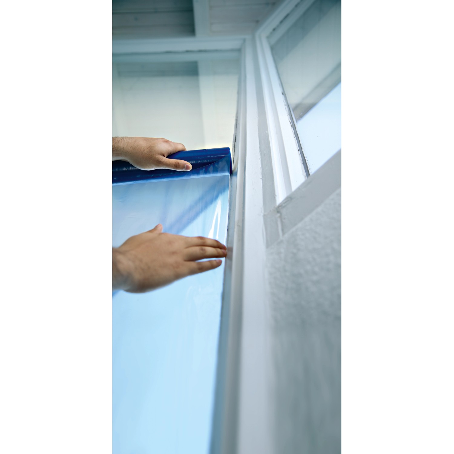 Applicazione della pellicola protettiva per finestre LUX blu al telaio della finestra.