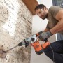 Uomo fora muro in pietra con martello perforatore Black+Decker BEHS03K. Potenza 1250 W.