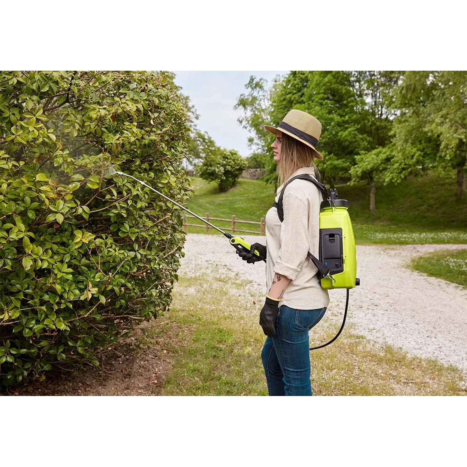 Donna usa t.b.t. pompa a pressione a spalla per giardinaggio. Spruzzatore a pressione in uso.