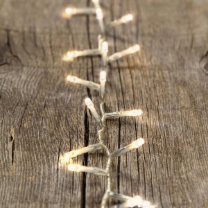 Primo piano di luci decorative da esterno bianco caldo su legno.