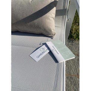 Dettaglio di un set di mobili da giardino con cuscino ed etichetta.