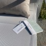 Dettaglio di un set di mobili da giardino con cuscino ed etichetta.