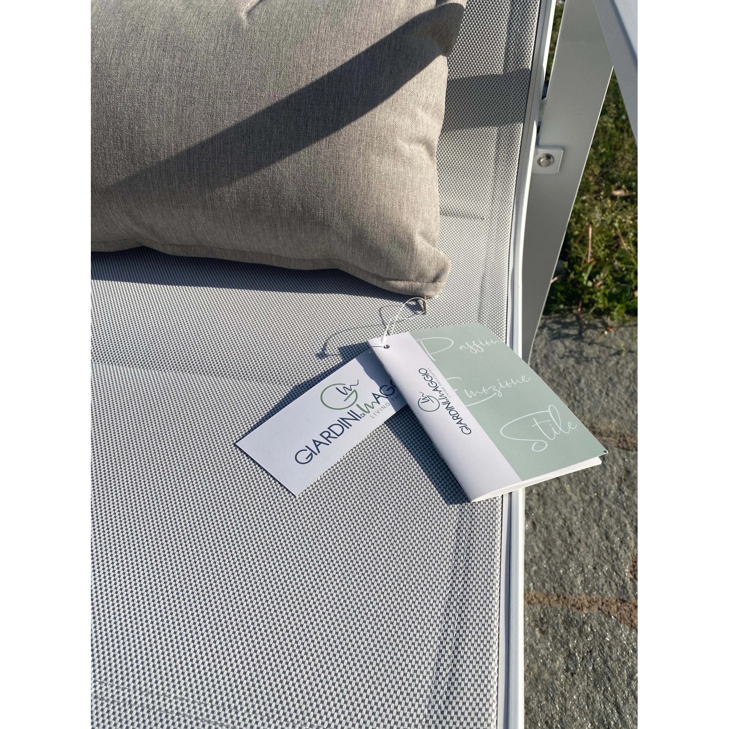 Dettaglio di un set di mobili da giardino con cuscino ed etichetta.