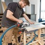 Troncatrice a batteria Bosch GKS 18V-57 G in uso con aspirazione e binario di guida.