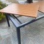 Tavolo da giardino allungabile con piano effetto legno e struttura in metallo grigio.