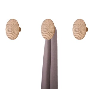 Tre appendiabiti t.b.t. in legno chiaro, uno con un panno grigio.